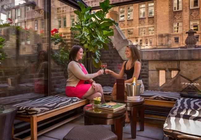Women enjoying cocktails on the Writer's Den terrace.